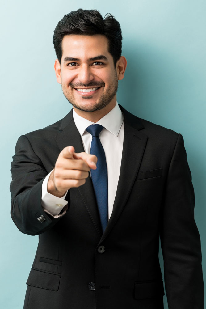 confident-good-looking-young-businessman-pointing-finger-while-standing-against-isolated-background